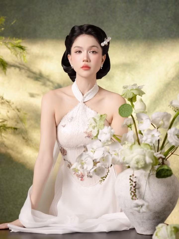Sự kết hợp giữa áo dài truyền thống và chi tiết cổ yếm hiện đại tạo nên điểm nhấn mới mẻ, phù hợp với không khí lễ Tết nhưng vẫn bắt kịp xu hướng thời trang đương đại. ngoc-trinh-12.jpg