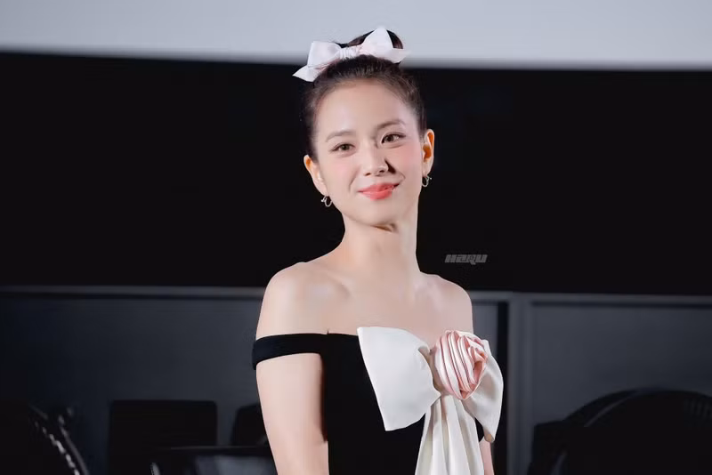 Jisoo trông thanh lịch trong chiếc váy liền thân màu đen đáng yêu được trang trí bằng một chiếc nơ lớn màu hồng nhạt ở giữa. jisoo-2.png