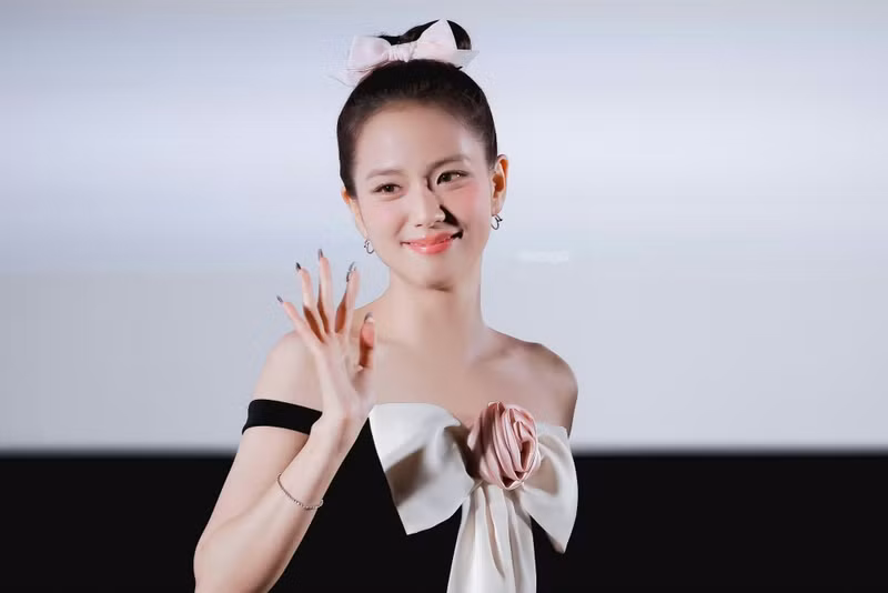 Hoàn thiện vẻ ngoài của mình, cô ấy lựa chọn kiểu tóc búi cao, với điểm nhấn bằng một chiếc nơ màu hồng nhạt cùng màu với chiếc nơ của váy. jisoo-3.png