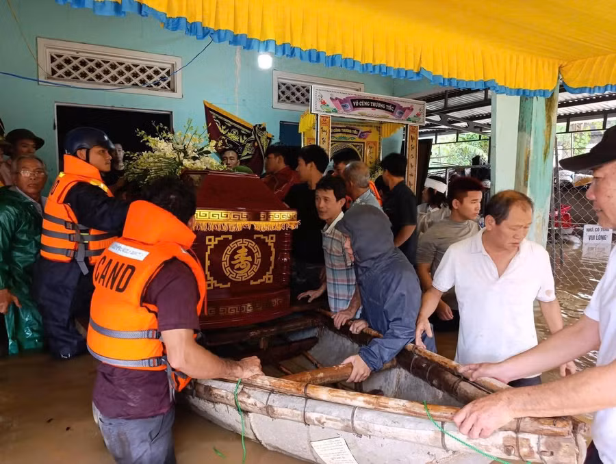 Lực lượng Bộ đội hỗ trợ đưa linh cữu cụ bà T. đi an táng trong điều kiện nước lũ ngập sâu.