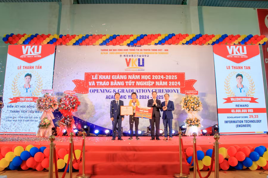 Ông Ngô Xuân Thắng (thứ 2, phải qua) - Chủ tịch HĐND TP Đà Nẵng và lãnh đạo Trường VKU trao học bổng cho tân thủ khoa Lê Thanh Tấn. 