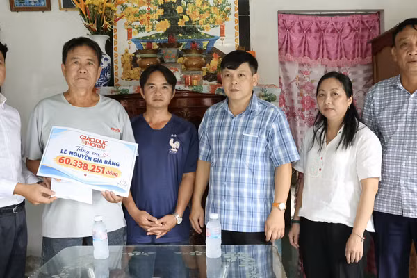 Báo GD&TĐ trao số tiền bạn đọc ủng hộ cho gia đình Lê Nguyễn Gia Bằng trước sự chứng kiến của Chủ tịch UBND phường Long Mỹ, ông Nguyễn Minh Hiền (thứ tư từ trái sang) và bà Lý Lệ Hoa, Phó Chủ tịch Ủy ban MTTQ Việt Nam - Chủ tịch Hội Nông dân phường.