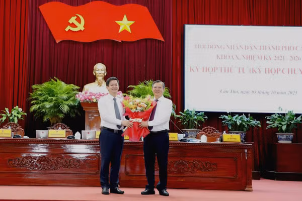 Tân Bí thư Thành ủy Cần Thơ Lê Quang Tùng (trái) tặng hoa chúc mừng tân Chủ tịch UBND TP Cần Thơ Trương Cảnh Tuyên.
