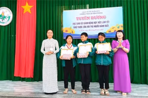 Cô giáo Nguyễn Thị Thái, Hiệu trưởng Nhà trường (áo dài tím) trao Giấy khen cho 3 học sinh. (Ảnh: CTV)