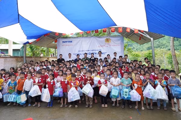 Cục Xây dựng phong trào bảo vệ ANTQ, công an tỉnh Cao Bằng và đại diện Nhựa Duy Tân, tặng quà cho điểm Trường Tiểu học Nà Đon (xã Quảng Lâm). Ảnh: BTC