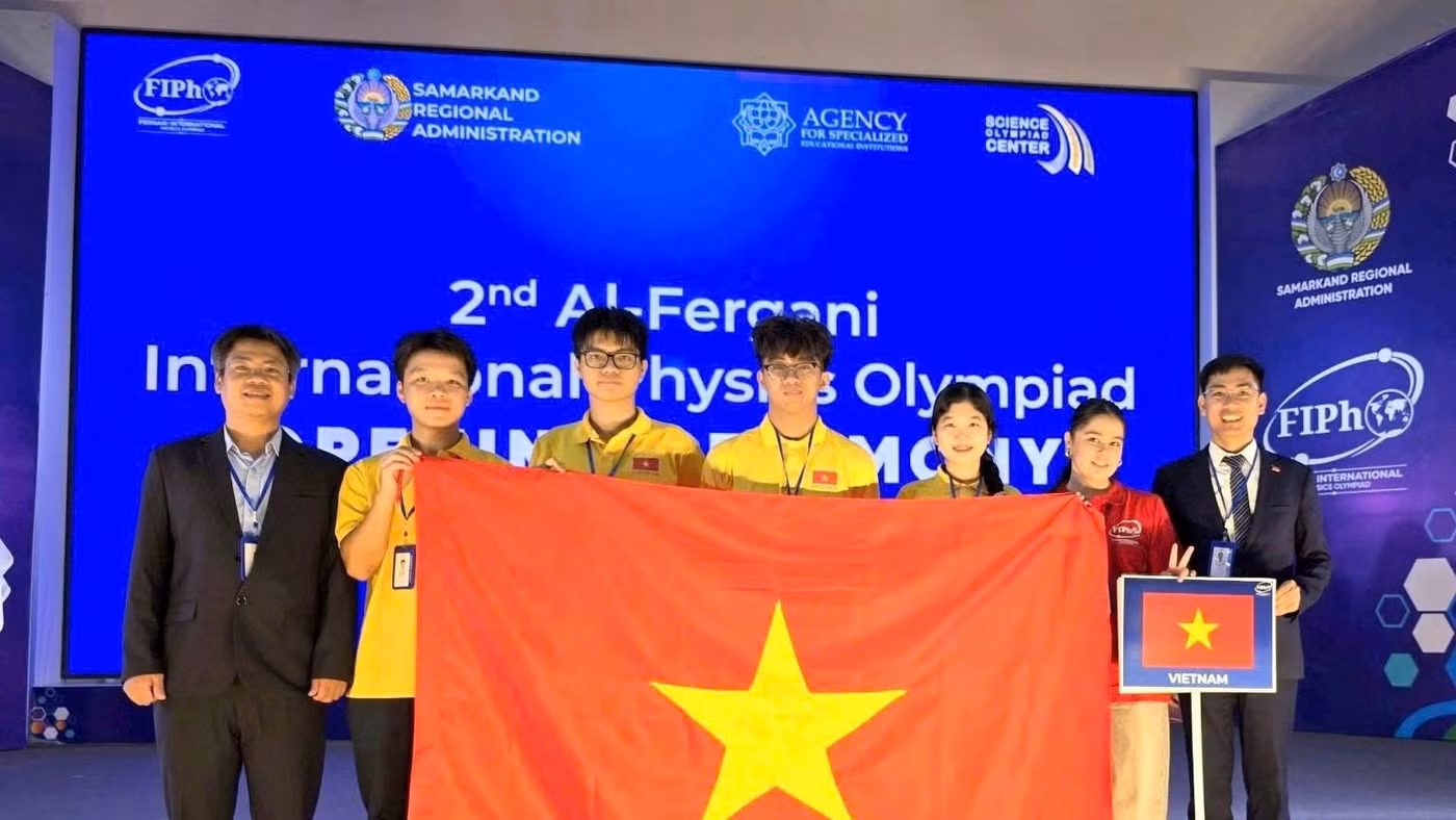 Đoàn học sinh Việt Nam tại FiPhO 2026 (Từ trái qua phải: PGS.TS Phạm Văn Hải, em Trương Bá Chí Thành, em Lê Bá Tuấn Việt, em Tăng Hạo Nhiên, em Lê Hồng Nhân, tình nguyện viên và PGS.TS Nguyễn Công Toản).