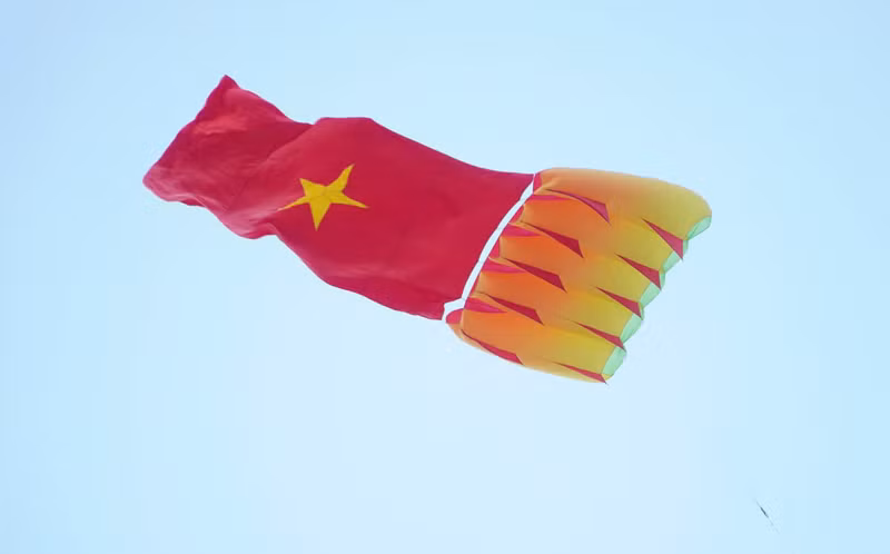 Cánh diều mang theo lá cờ đỏ sao vàng tung bay trên bầu trời. z7955954915377-c42a1336b4df69e55f725cf7d9097f61.jpg