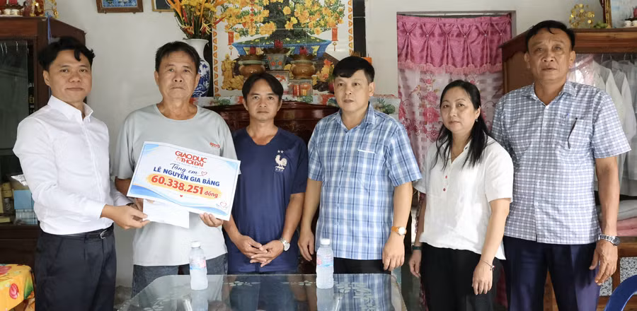 Báo GD&TĐ trao số tiền bạn đọc ủng hộ cho gia đình Lê Nguyễn Gia Bằng trước sự chứng kiến của Chủ tịch UBND phường Long Mỹ, ông Nguyễn Minh Hiền (thứ tư từ trái sang) và bà Lý Lệ Hoa, Phó Chủ tịch Ủy ban MTTQ Việt Nam - Chủ tịch Hội Nông dân phường.
