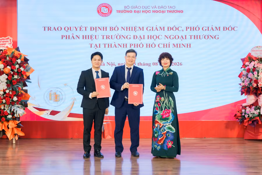 TS Nguyễn Bình Minh (giữa) nhận quyết định điều động, bổ nhiệm giữ chức vụ Giám đốc Phân hiệu Trường Đại học Ngoại thương tại TPHCM. Ảnh: NTCC.