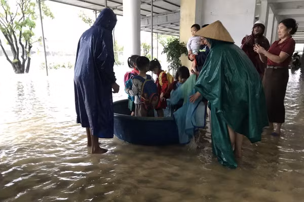 Lực lượng chức năng và giáo viên hỗ trợ đưa học sinh ra khỏi khu vực ngập ở Trường Mầm non Kỳ Thịnh (Phường Vũng Áng, Hà Tĩnh).
