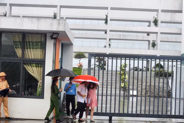 Các thí sinh rời phòng thi trong thời tiết có mưa.