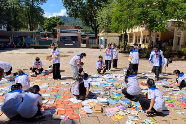 Học sinh Trường THCS Lý Tự Trọng cặm cụi phơi những cuốn sách còn phục hồi được.