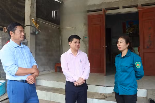 Cán bộ xã Yên Trạch và Ngân hàng Chính sách xã hội trao đổi với chị Đặng Minh Huệ.