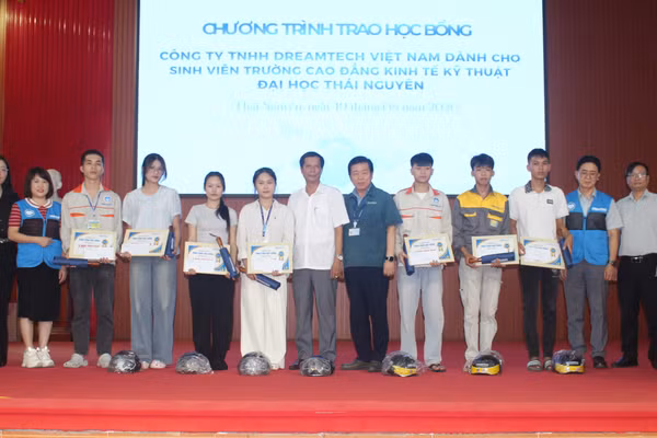 Đại diện doanh nghiệp trao học bổng cho sinh viên.