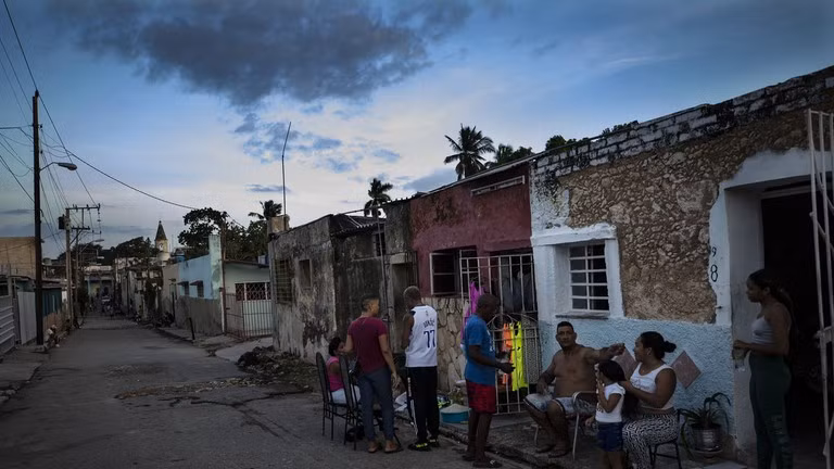 Người dân trò chuyện bên ngoài nhà trong thời gian mất điện nhiều ngày ở Havana, Cuba.