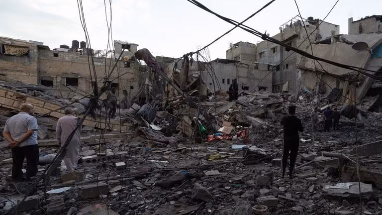 Người dân đang kiểm tra một tòa nhà bị phá hủy sau cuộc không kích của Israel tại Dải Gaza.