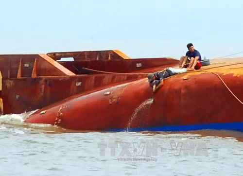 Lực lượng cứu hộ triển khai hàn cắt, phá lớp vỏ tàu để tìm kiếm 4 người còn mất tích. Ảnh: Mạnh Linh-TTXVN