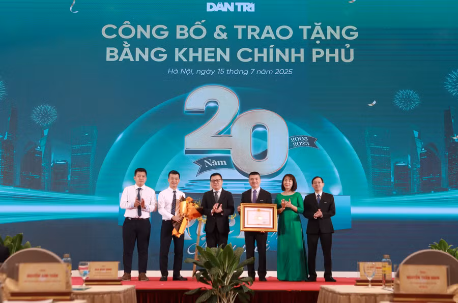 Nhà báo Lê Quốc Minh, Tổng Biên tập Báo Nhân Dân, Phó Trưởng Ban Tuyên giáo và Dân vận Trung ương trao Bằng khen của Thủ tướng cho Báo Dân trí. (Ảnh: Đình Tuệ)