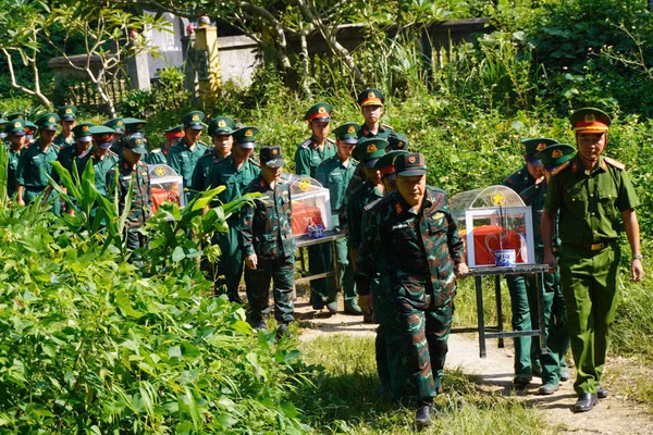 Lực lượng chức năng thực hiện di chuyển hài cốt liệt sĩ.