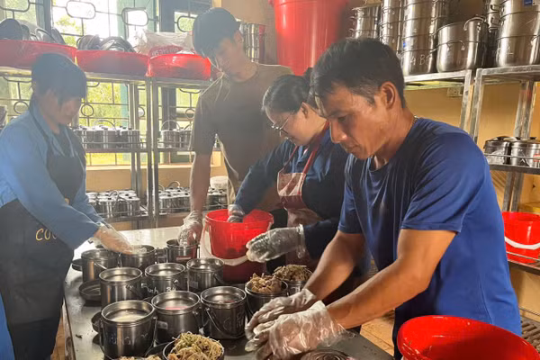 Nhân viên nhà bếp Trường PTDTNT THPT Mường Nhé chia thức ăn cho học sinh.