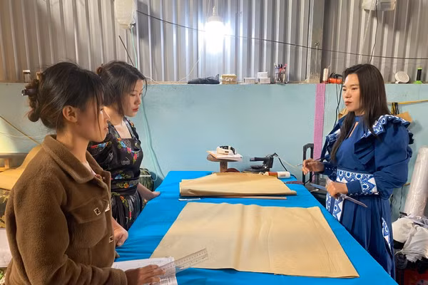 Chị Giàng Thị Mỷ (bên phải) hướng dẫn các học viên học nghề may.