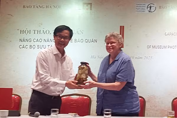 Ông Nguyễn Tiến Đà, Giám đốc Bảo tàng Hà Nội tặng quà kỷ niệm cho bà Barbara (phải) trong buổi khai mạc sự kiện. Ảnh: Bình Thanh