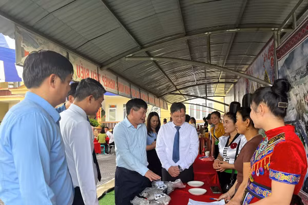 Ông Lê Thành Đô (thứ 3 tính từ bên trái) cùng các đại biểu thăm gian hàng trưng bày sản phẩm nông nghiệp của xã Chiềng Sinh.