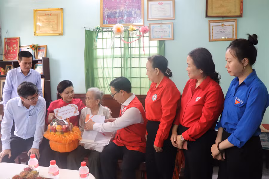 Ông Nguyễn Minh Nhựt, Chủ tịch Hội Chữ thập đỏ TPHCM trao quà đến các gia đình chính sách, người có công với cách mạng.
