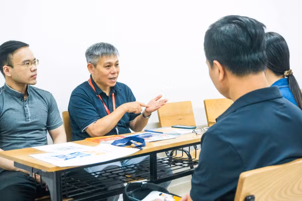 PGS.TS Lê Hiếu Học (hàng thứ hai, bên phải) - Trưởng khoa Khoa học và Công nghệ Giáo dục, Đại học Bách khoa Hà Nội phân tích cho phụ huynh, thí sinh.
