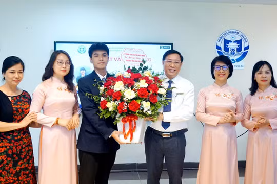 Thầy Tuấn nhận hoa tri ân từ em Nguyễn Nhật Minh, lớp 11 chuyên Lý, Trường THPT chuyên Khoa học Tự nhiên, Đại học Quốc gia Hà Nội giành Huy chương Vàng tại Olympic Vật lý quốc tế 2026. Ảnh NTCC.