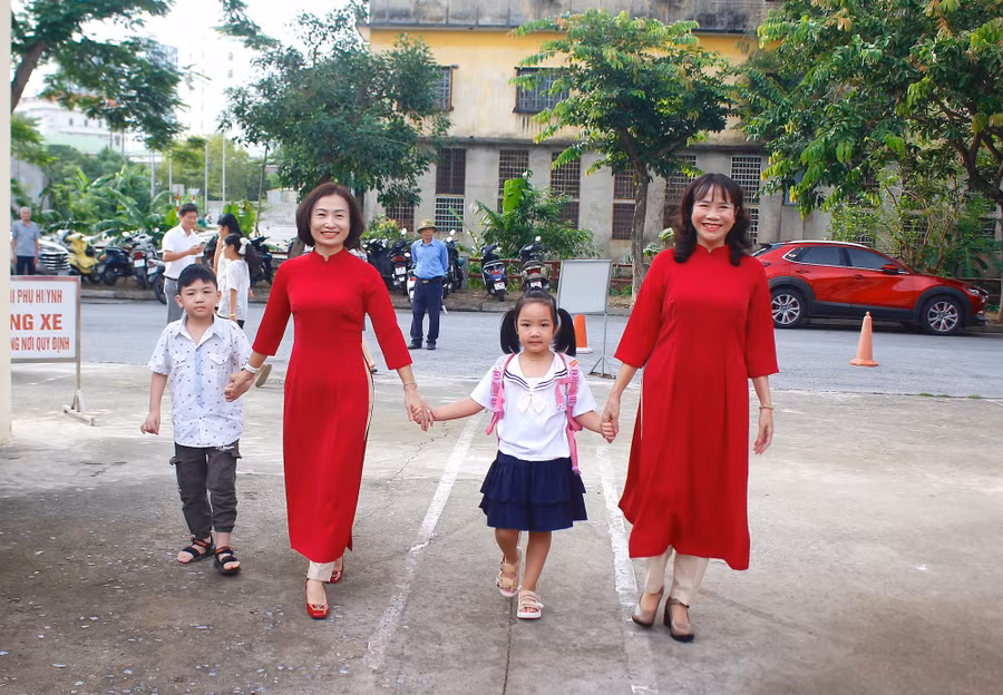 Cô giáo ân cần dắt tay học sinh lớp 1 trong ngày đầu tiên tới trường.