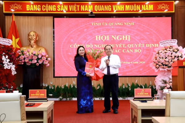 Ông Quản Minh Cường, Bí thư Tỉnh ủy Quảng Ninh trao quyết định, tặng hoa chúc mừng bà Nguyễn Thị Hiền, Bí thư Đảng ủy phường Móng Cái 1.