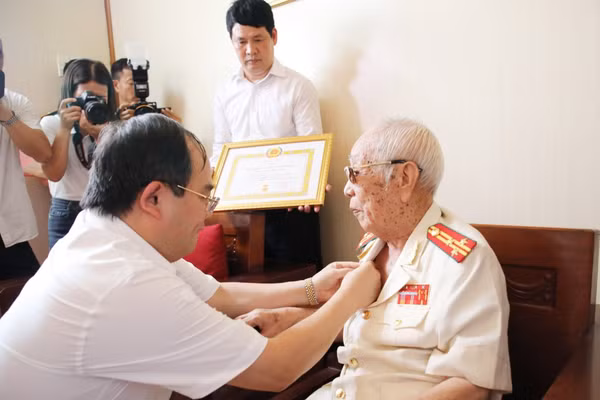 Ông Quản Minh Cường, Bí thư Tỉnh ủy Quảng Ninh trao Huy hiệu 80 năm tuổi Đảng cho cụ Vũ Đức Kính.