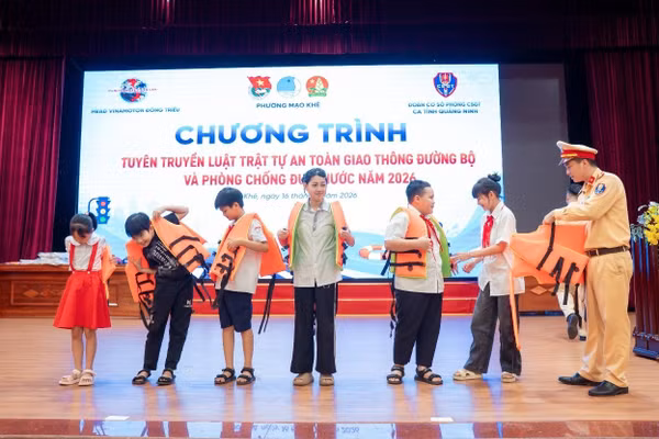 Hướng dẫn học sinh mặc áo phao đúng quy định.
