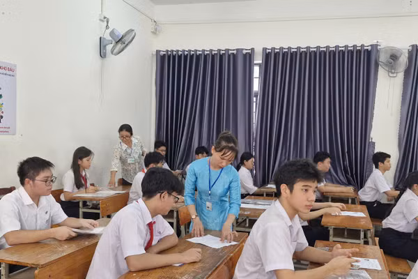 Cán bộ làm công tác thi hướng dẫn thí sinh rà soát, đối chiếu thông tin trên thẻ dự thi. 
