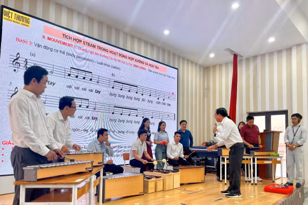 Giáo viên âm nhạc thực hành với các loại nhạc cụ để tổ chức hoạt động hòa tấu đơn giản tại lớp tập huấn. 
