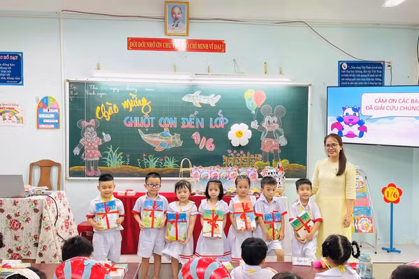 Học sinh khối lớp 1 Trường Tiểu học Huỳnh Ngọc Huệ được tặng bộ sách giáo khoa mới trong ngày tựu trường. Ảnh: NTCC