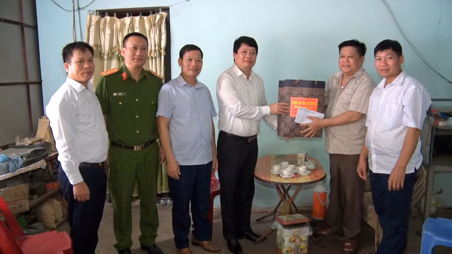 Ông Lê Văn Thạch, Bí thư Huyện ủy Tân Lạc (người thứ 4 từ trái sang) đến thăm và tặng quà người dân.