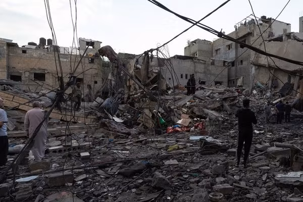 Người dân đang kiểm tra một tòa nhà bị phá hủy sau cuộc không kích của Israel tại Dải Gaza.