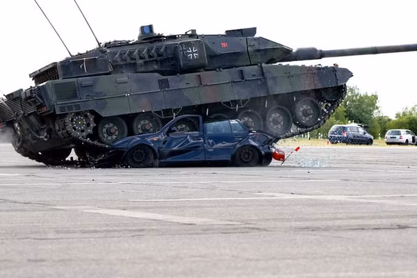 Các binh sĩ Đức trình diễn khả năng của xe tăng chiến đấu chủ lực Leopard 2A7V và lái xe cán qua một chiếc VW Golf cũ trong Ngày Quân đội trên khuôn viên Đại học Bundeswehr. 