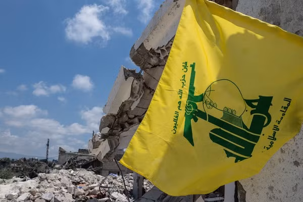 Một lá cờ Hezbollah treo trên tòa nhà bị phá hủy bởi cuộc không kích của IDF, tại Sidon, Lebanon, ngày 23/6.