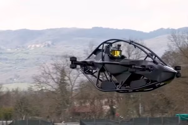 Máy bay eVTOL Jetson ONE đang bay giữa không trung trên một cánh đồng với dãy núi phía sau. Ảnh: Jetson