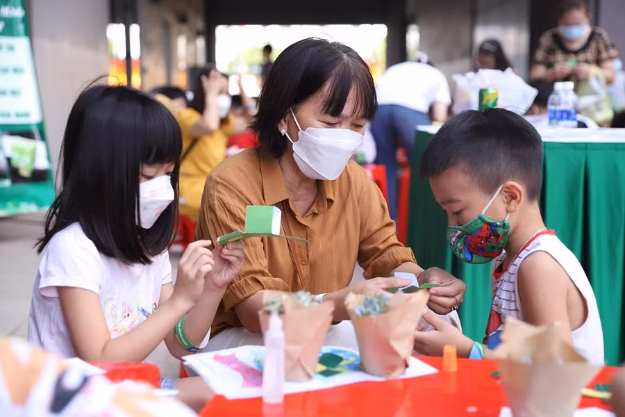 Các em nhỏ chăm chú cắt ráp anh hùng rùa xanh bằng giấy