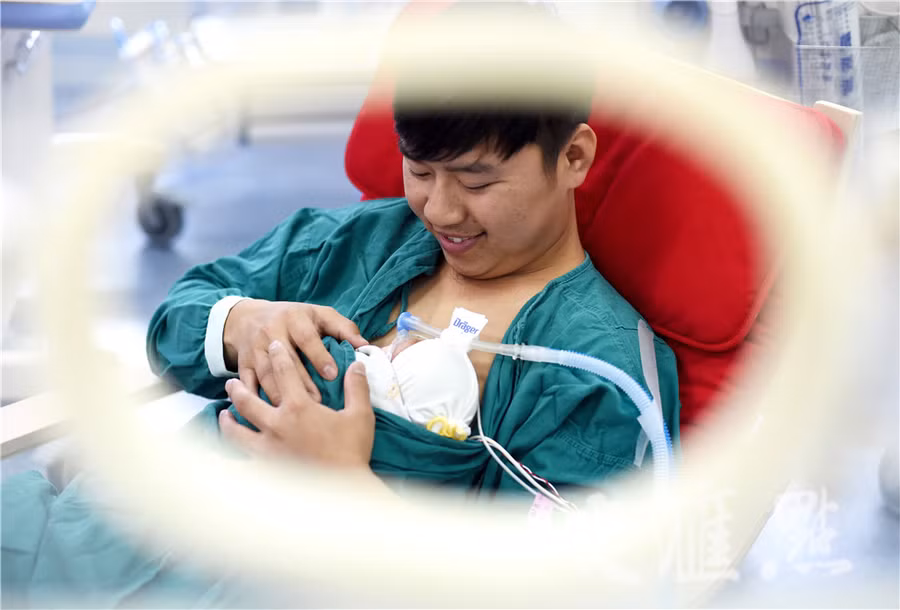 Hình ảnh hai ông bố ôm con sinh non cho bú gây xúc động - Ảnh 1