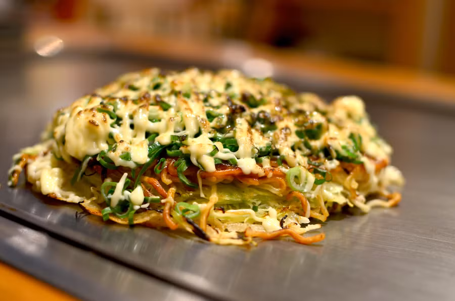Okonomiyaki, Nhật Bản: Chiếc bánh làm từ bột, trứng kết hợp với rau bắp cải và thêm những gì bạn thích, từ bạch tuộc với phô mai. Sau đó rán và rắc thêm chút gừng ngâm, sốt mayonnaise. Chiếc bánh này còn được biết đến là “Pizza Nhật”. Ảnh: Omnomculture. Okonomiyaki, Nhật Bản: Chiếc bánh làm từ bột, trứng kết hợp với rau bắp cải và thêm những gì bạn thích, từ bạch tuộc với phô mai. Sau đó rán và rắc thêm chút gừng ngâm, sốt mayonnaise. Chiếc bánh này còn được biết đến là “Pizza Nhật”. Ảnh: Omnomculture.