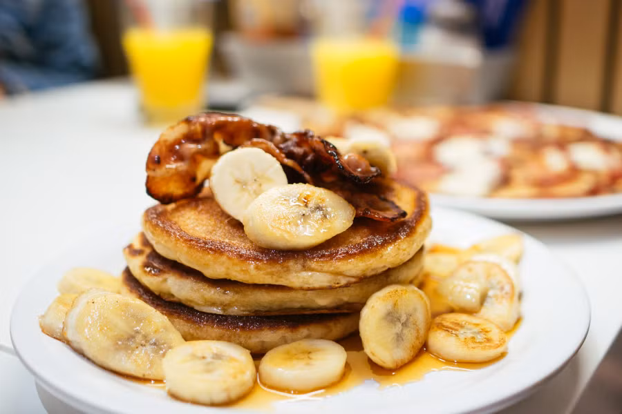 Pancake, Mỹ: Bánh pancake ở Mỹ khá dày và bông mịn, ăn kèm chuối, blueberry, siro cây thích và thịt hun khói chiên giòn. Ảnh: Thatfoodcray. Pancake, Mỹ: Bánh pancake ở Mỹ khá dày và bông mịn, ăn kèm chuối, blueberry, siro cây thích và thịt hun khói chiên giòn. Ảnh: Thatfoodcray.