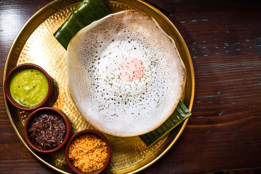 Hoppers, Sri Lanka: Là những chiếc bánh pancake có viền ngoài vàng giòn, phần giữa lại mềm. Bánh hoppers ăn kèm với cà ri, gia vị, và đôi khi có thêm một quả trứng. Ảnh: Bloomberg. Hoppers, Sri Lanka: Là những chiếc bánh pancake có viền ngoài vàng giòn, phần giữa lại mềm. Bánh hoppers ăn kèm với cà ri, gia vị, và đôi khi có thêm một quả trứng. Ảnh: Bloomberg.