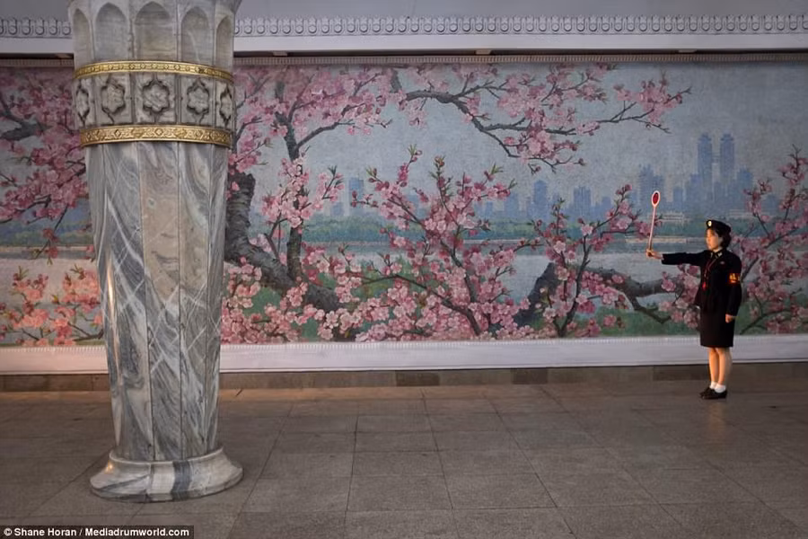Một công nhân nhà ga Glory ở Bình Nhưỡng đang đón một chiếc tàu chuẩn bị tới.
