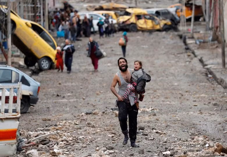 Một người đàn ông đang khóc khi đang bế con gái đi từ một phần của Mosul đang bị IS nắm giữ sang phía lực lượng của Iraq Một người đàn ông đang khóc khi đang bế con gái đi từ một phần của Mosul đang bị IS nắm giữ sang phía lực lượng của Iraq