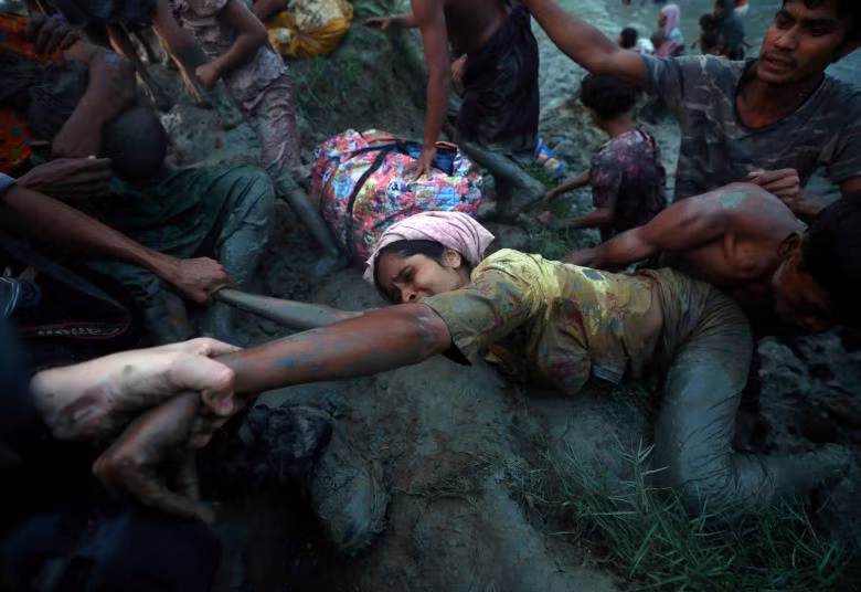 Những nhiếp ảnh gia giúp một người tị nạn Rohingya ra khỏi sông Nad River khi họ đi qua biên giới Myanmar - Bangladesh Những nhiếp ảnh gia giúp một người tị nạn Rohingya ra khỏi sông Nad River khi họ đi qua biên giới Myanmar - Bangladesh